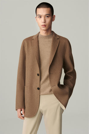 Three-quarter view highlighting the notched lapels and patch pockets of the brown blazer.