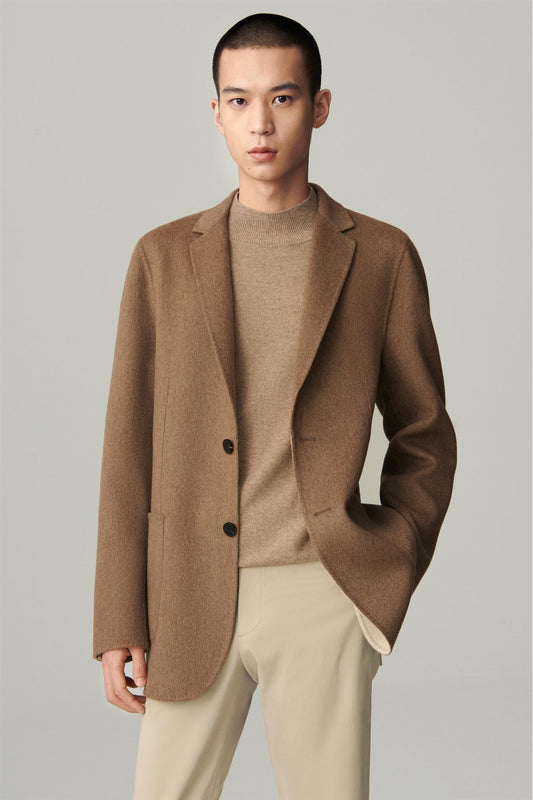 Three-quarter view highlighting the notched lapels and patch pockets of the brown blazer.