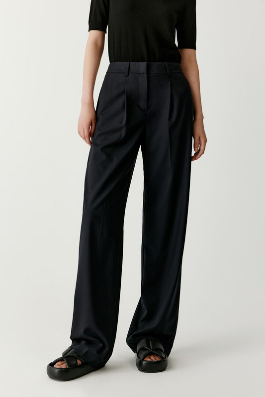 Front view emphasizing the fluid drape of the worsted wool fabric. The straight-leg silhouette remains consistent from hip to hem, allowing natural movement.