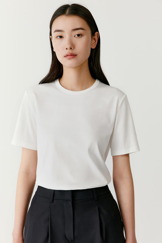 Front view focusing on the upper body showing the round neckline, short sleeves and smooth organic cotton jersey texture. The relaxed fit allows the fabric to fall naturally without clinging to the body.