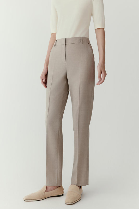 Side view emphasizing the gradual taper from the hips to the ankle. The lightweight worsted wool fabric drapes naturally while maintaining a structured appearance.