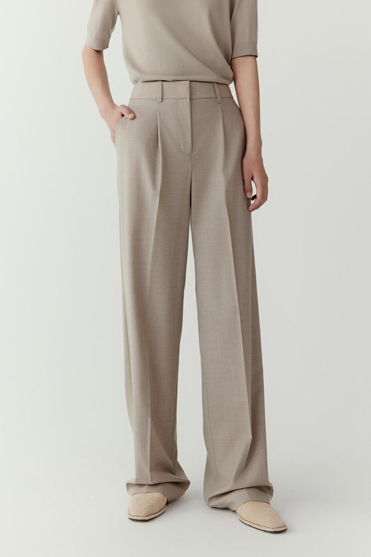 Front view emphasizing the fluid drape and lightweight structure of the worsted wool fabric. The trousers follow the natural movement of the body while preserving their clean shape.