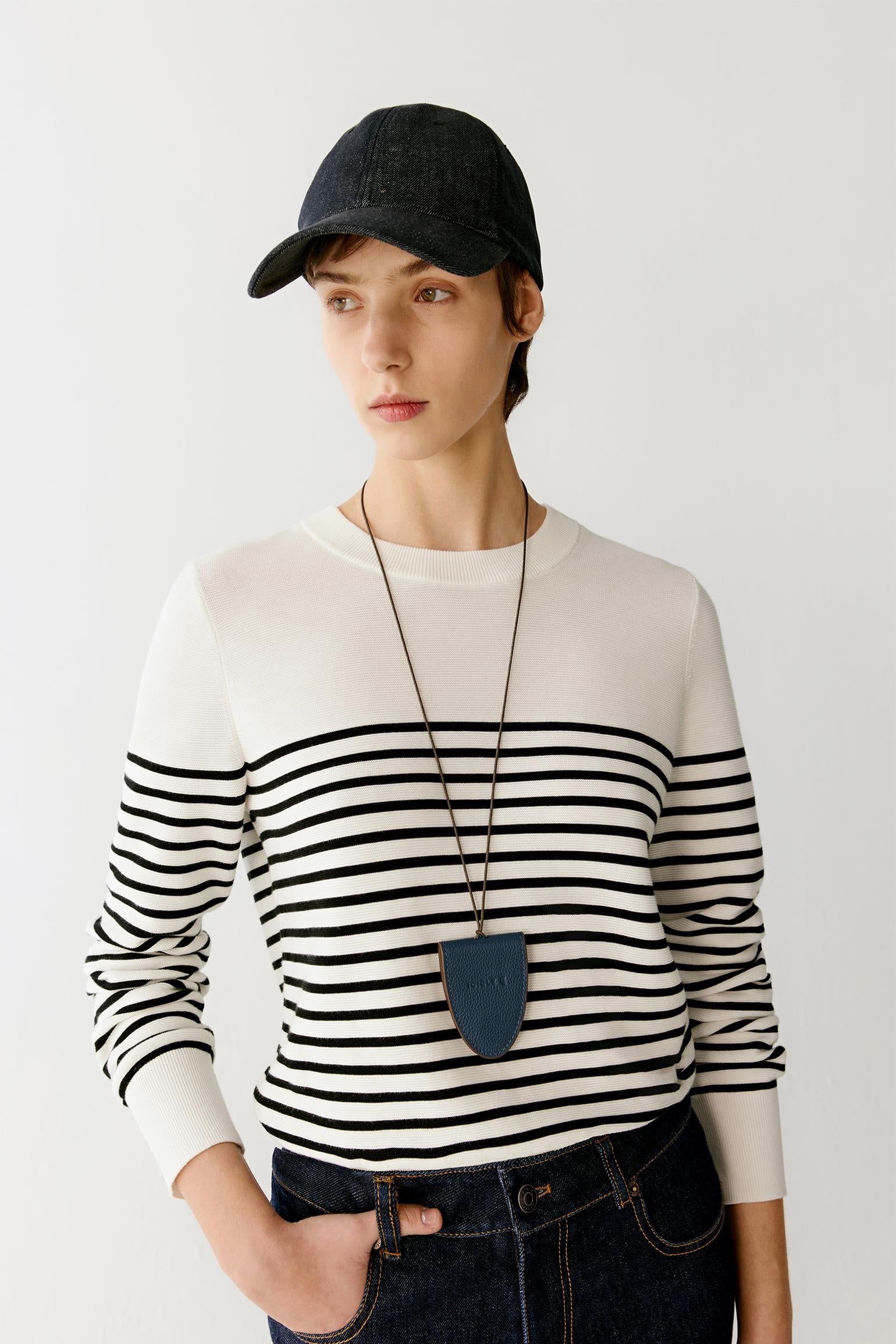 Side view highlighting the slim profile of the garment, the straight hemline and the way the knit fabric adapts to the body while maintaining a clean, continuous line