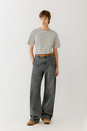 Front view of a woman wearing a striped cotton jersey T-shirt in a cream shade with black horizontal stripes, highlighting the smooth jersey surface, soft hand and relaxed straight silhouette. The evenly spaced stripe pattern creates subtle visual rhythm while maintaining a clean and balanced appearance.