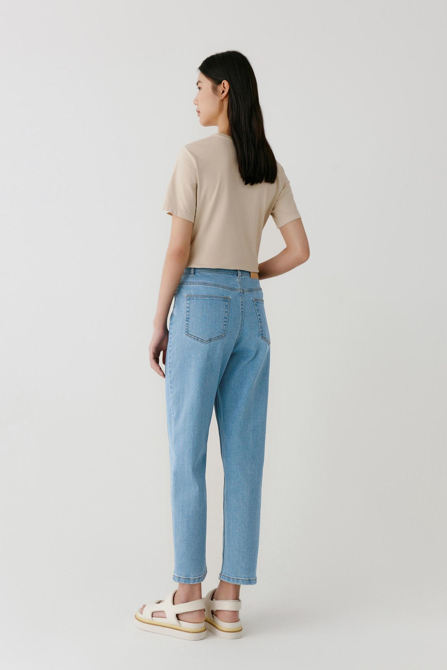 Three-quarter view highlighting the relaxed fit and natural movement of the fabric. The image showcases the clean shoulder line, straight body shape and soft drape that characterise the lightweight cotton jersey construction.