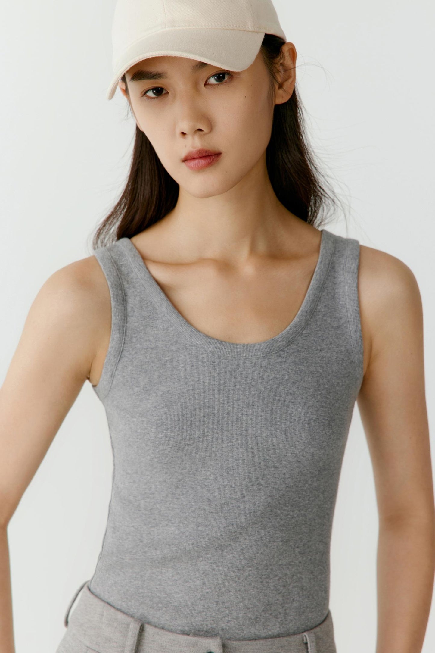 Close-up portrait focusing on the round neckline, shoulder line and ribbed texture. The image reveals the fine structure of the jersey and the clean finishing of the garment.