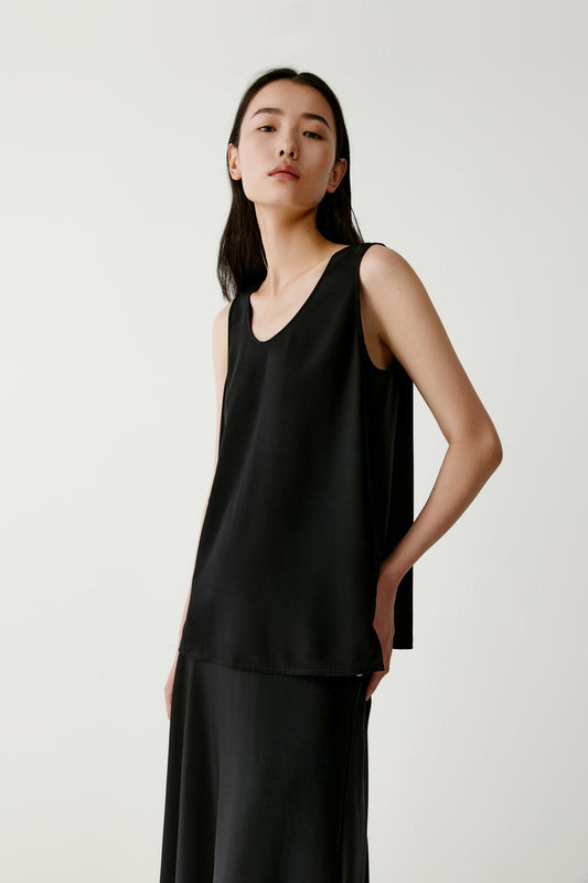 Three-quarter view showing the lightweight structure and fluid movement of the silk crêpe de Chine. The image emphasizes the relaxed fit, soft drape through the body and the subtle volume created by the flowing silhouette.