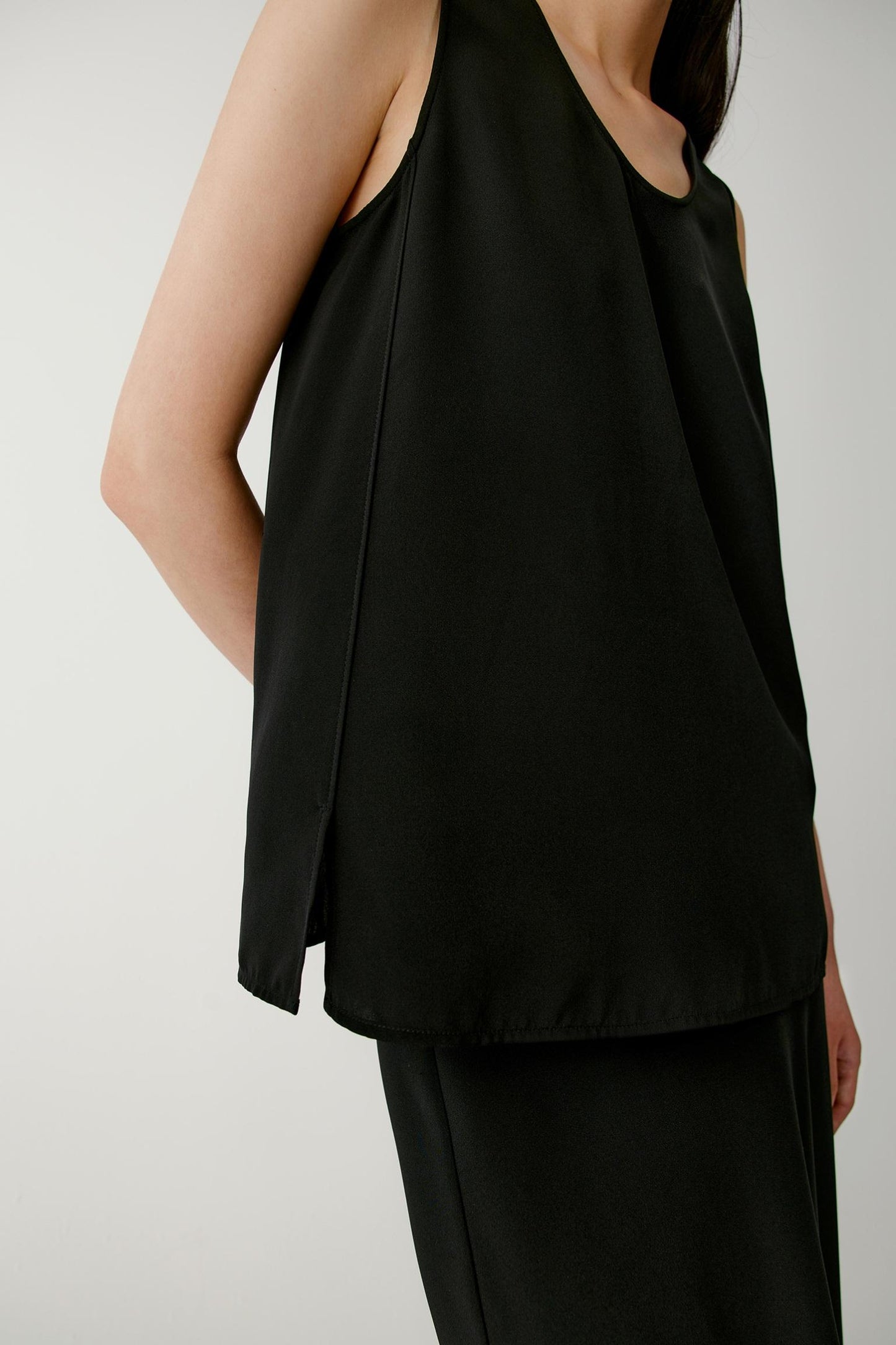 Close-up side view highlighting the side slit and fluid hemline. The image showcases the smooth fabric surface, relaxed silhouette and flowing drape of the silk crêpe de Chine, revealing the movement and lightweight character of the material.
