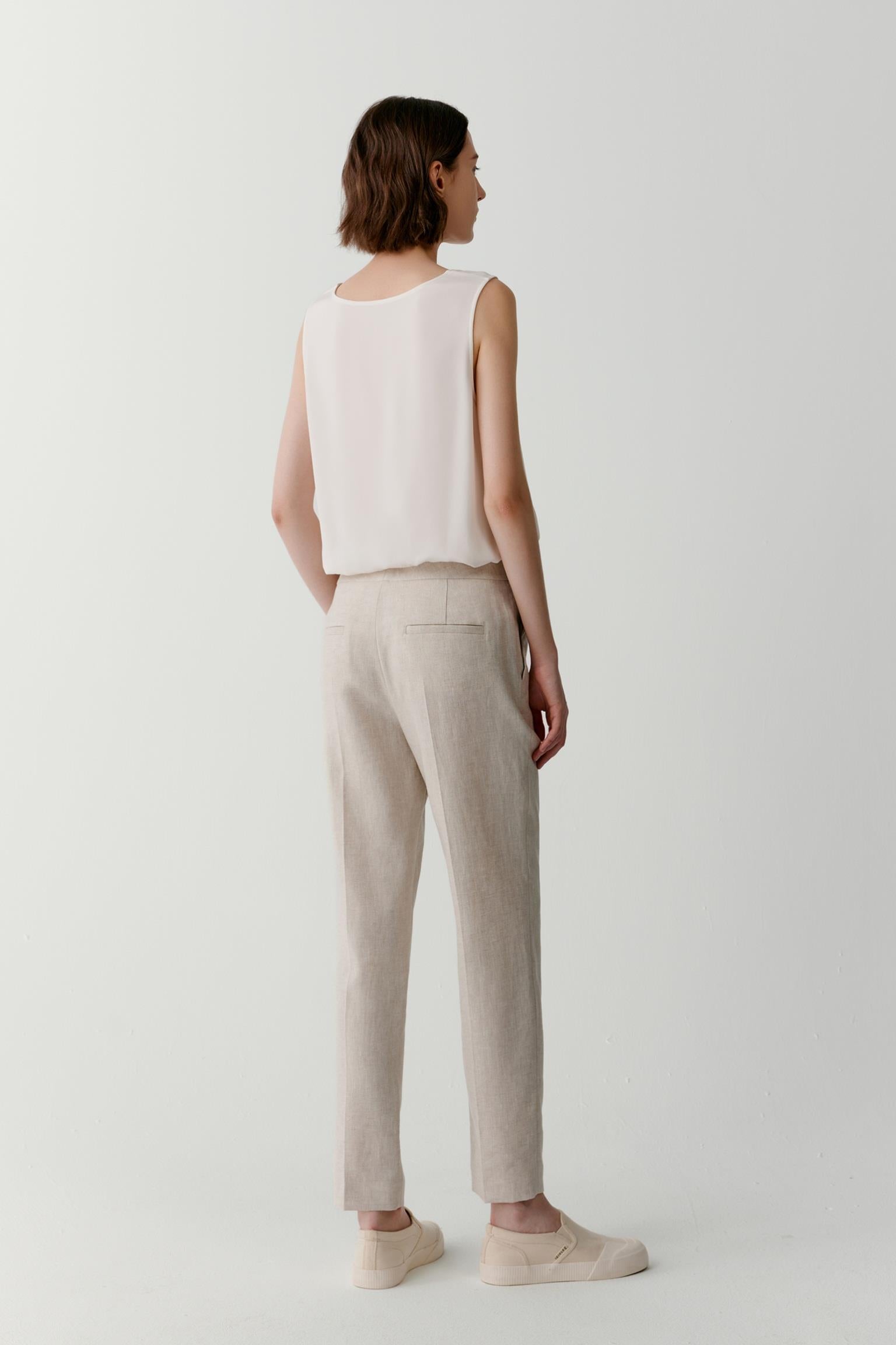 Side view highlighting the fluid fall of the fabric and the ease of the sleeveless construction. The image showcases the straight silhouette, lightweight structure and subtle movement created by the silk fabric.