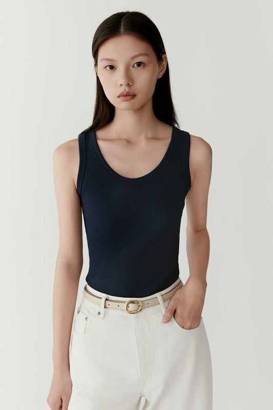 Three-quarter front view of the ribbed cotton tank top, highlighting the vertical rib texture and body-hugging fit.