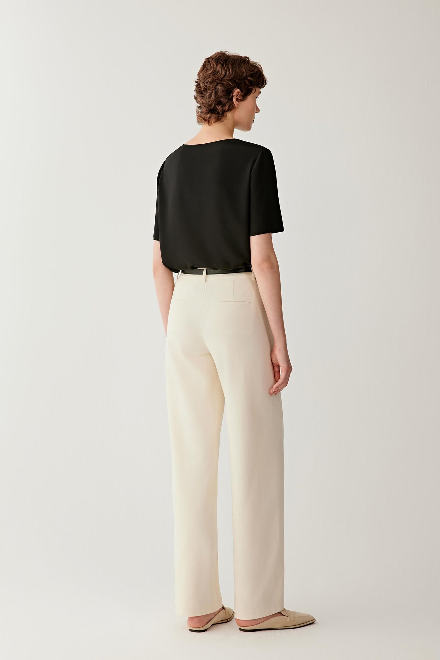 Back view showing the simple silhouette and uninterrupted drape of the fabric. The image highlights the clean finishing, relaxed fit and fluid structure of the silk crêpe de Chine, creating a balanced and refined appearance.