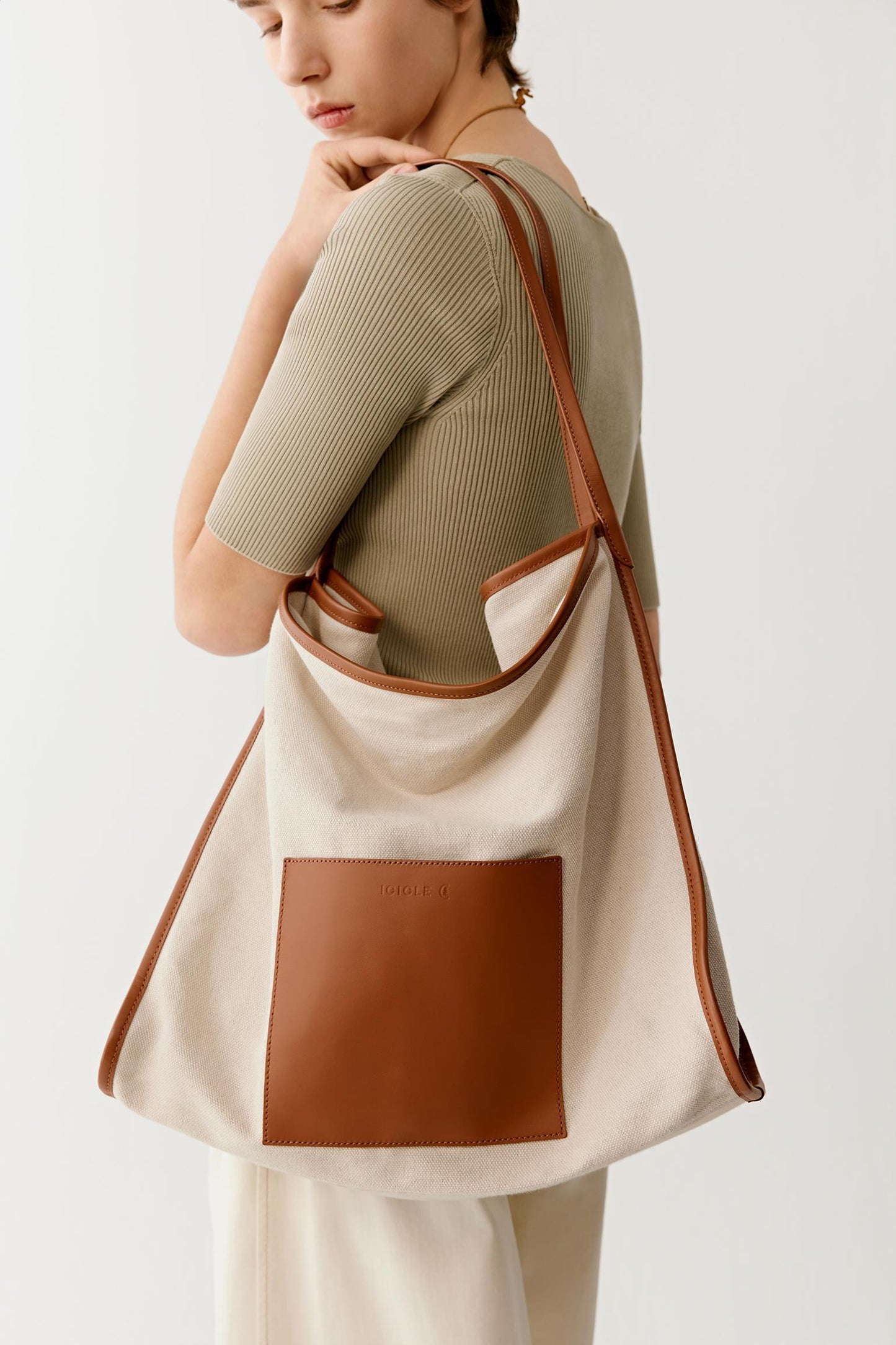 Side view highlighting the wide shoulder straps and the softly structured silhouette designed for comfortable everyday use.