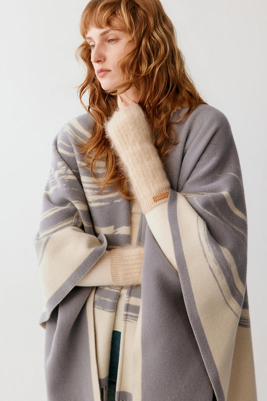 Front view of a woman wearing natural beige brushed cashmere fingerless gloves, showing the elongated ribbed construction and open fingers.