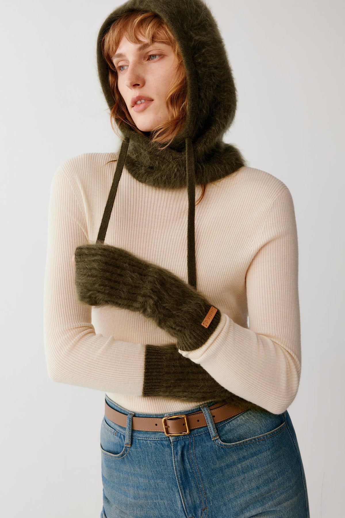 Front view of a woman wearing dark green brushed cashmere gloves, highlighting the elongated shape and ribbed cuffs.