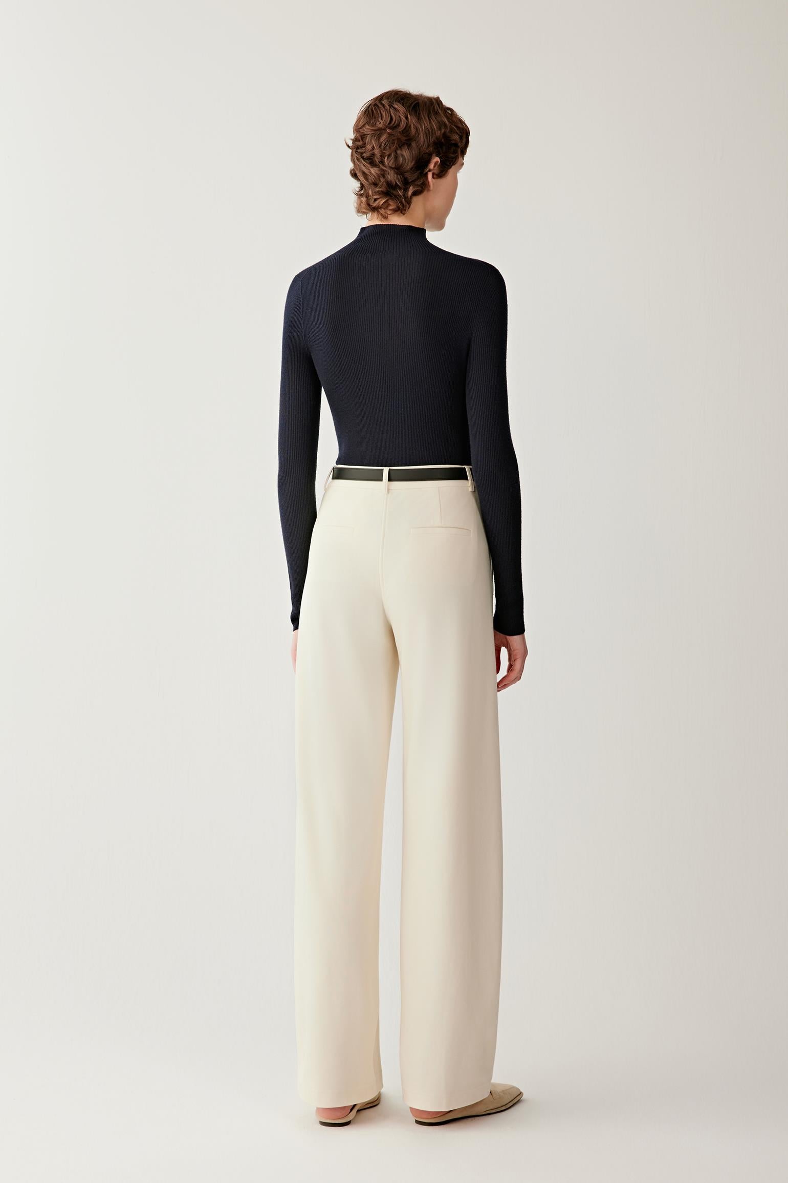 Full-length back view of women’s navy merino wool pullover with long sleeves