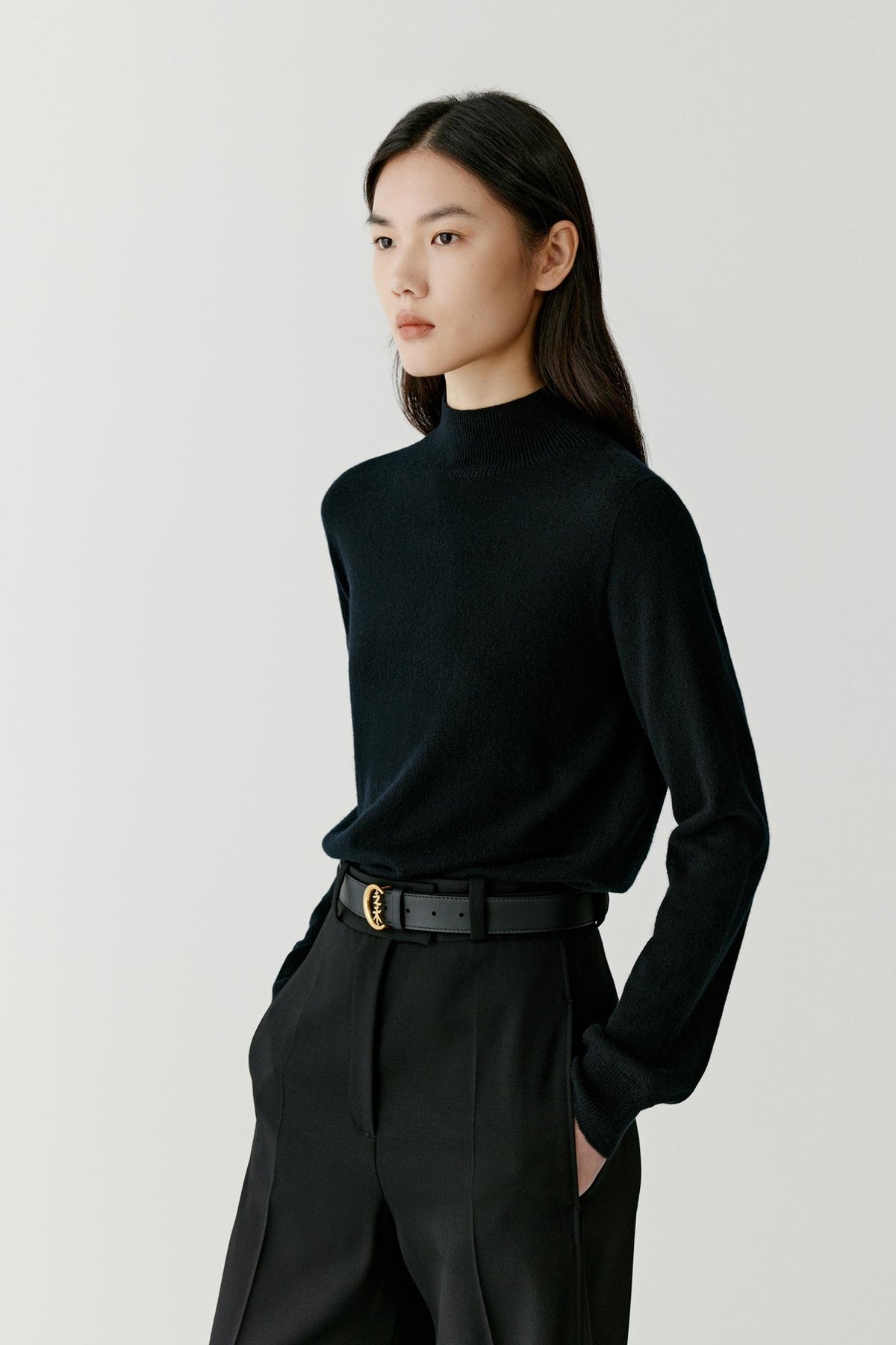 Three-quarter view highlighting the dropped shoulders, long sleeves and smooth cashmere surface.