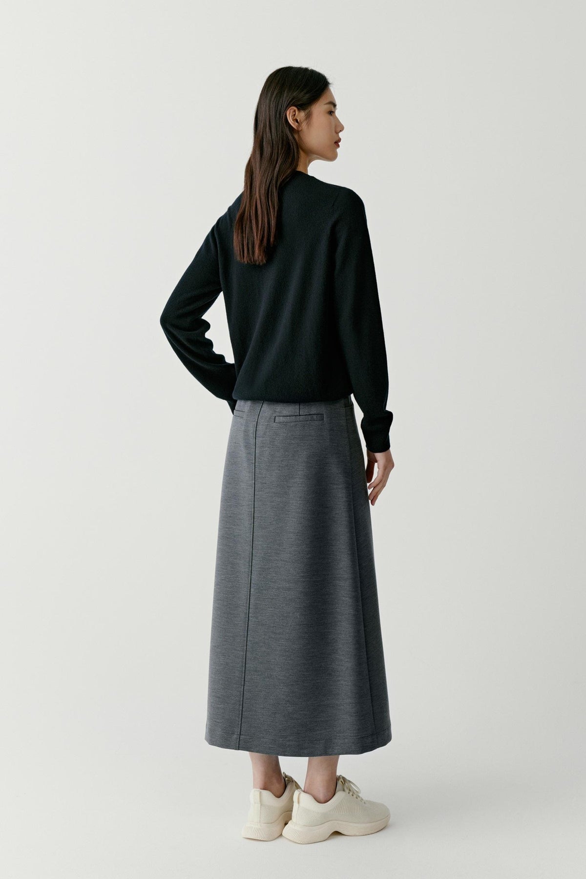 Three-quarter view highlighting the long sleeves, ribbed trims and clean silhouette of the deep black cashmere pullover.