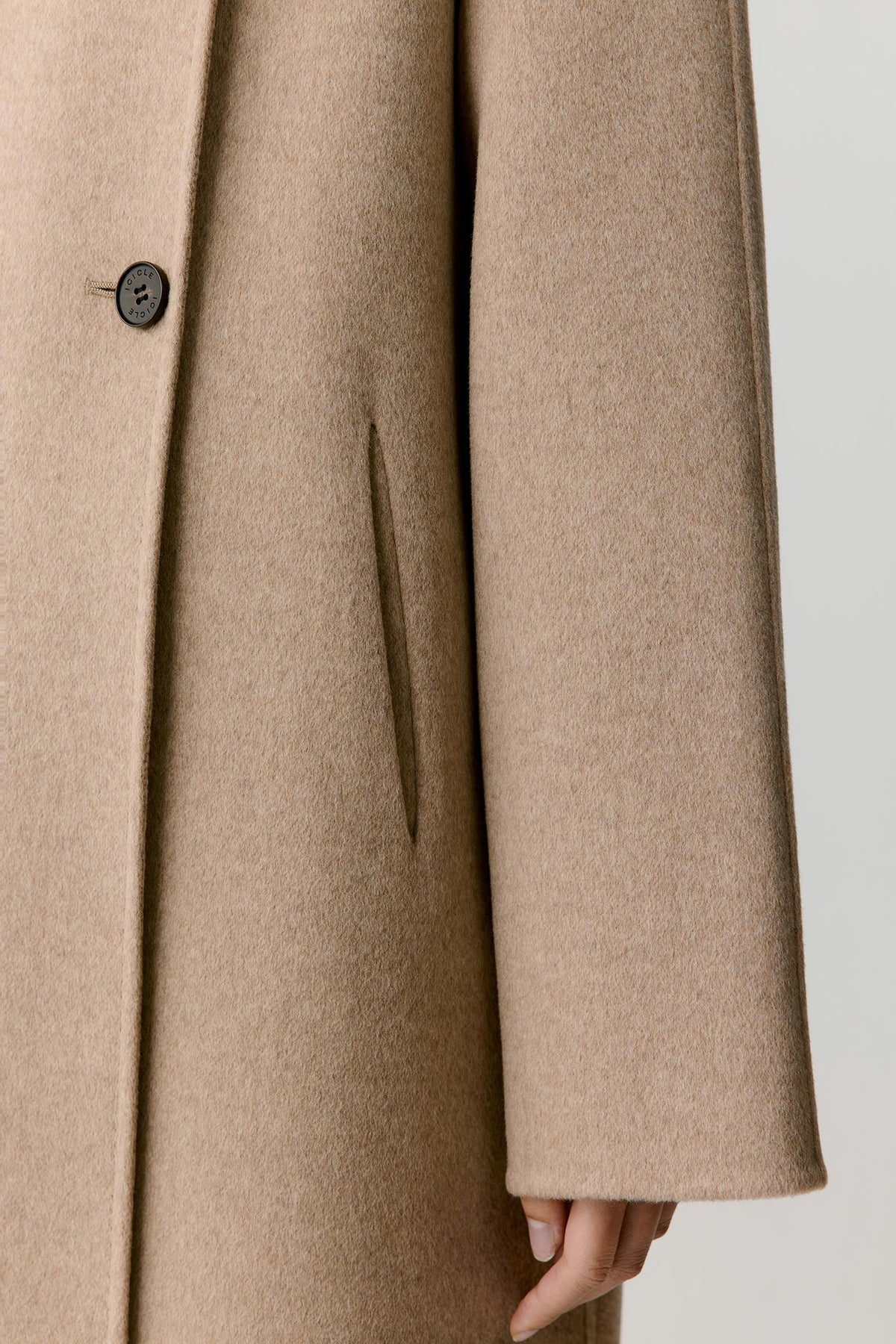 Close-up showing the long sleeve, clean cuff and dense double-face cashmere construction.