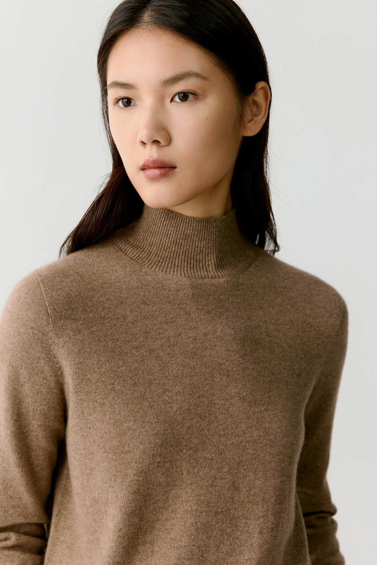 Close-up highlighting the mock neck and fine-knit texture of the taupe melange cashmere pullover.
