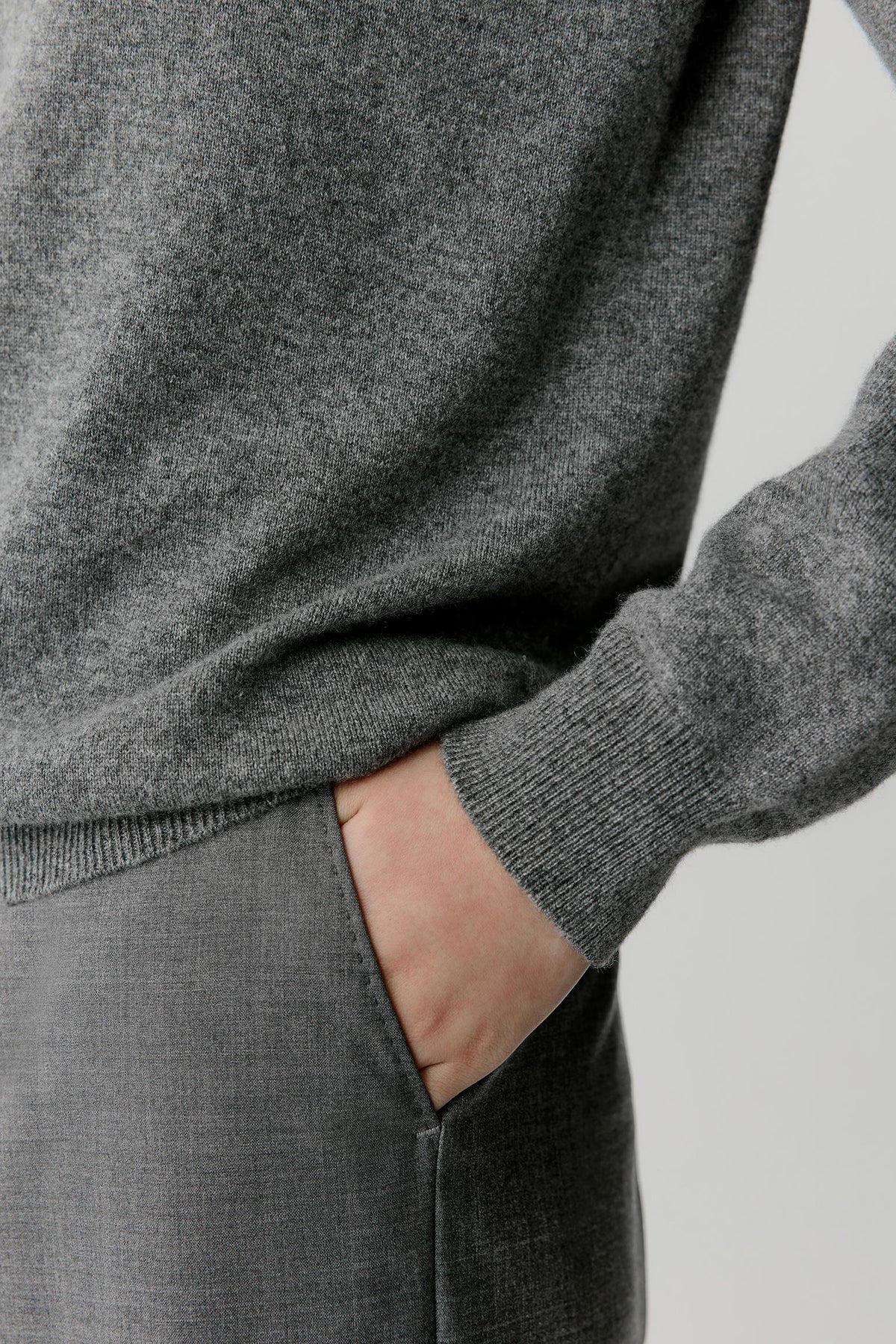 Close-up highlighting the long sleeve, ribbed cuff and soft smoky grey cashmere surface.