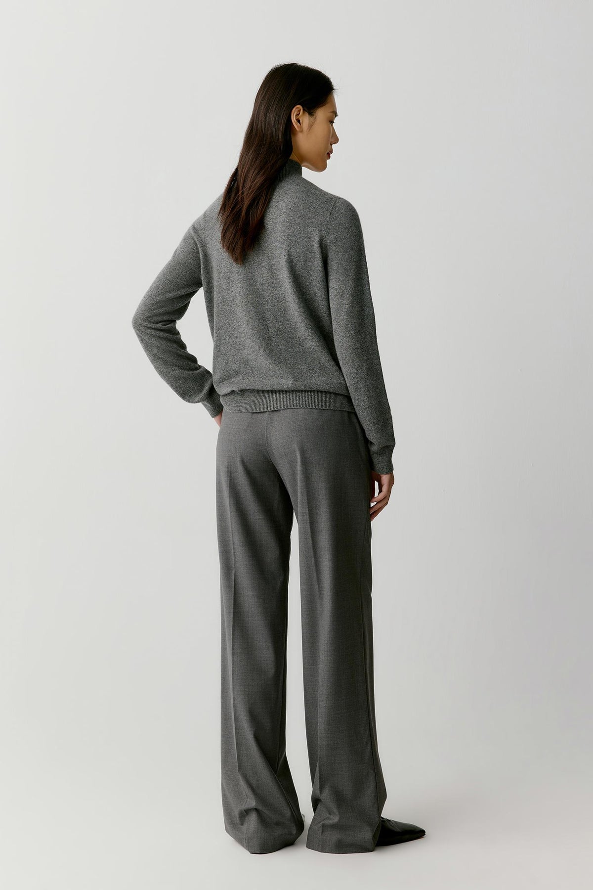 Three-quarter view highlighting the mock neck, long sleeves and relaxed silhouette of the smoky grey cashmere pullover.