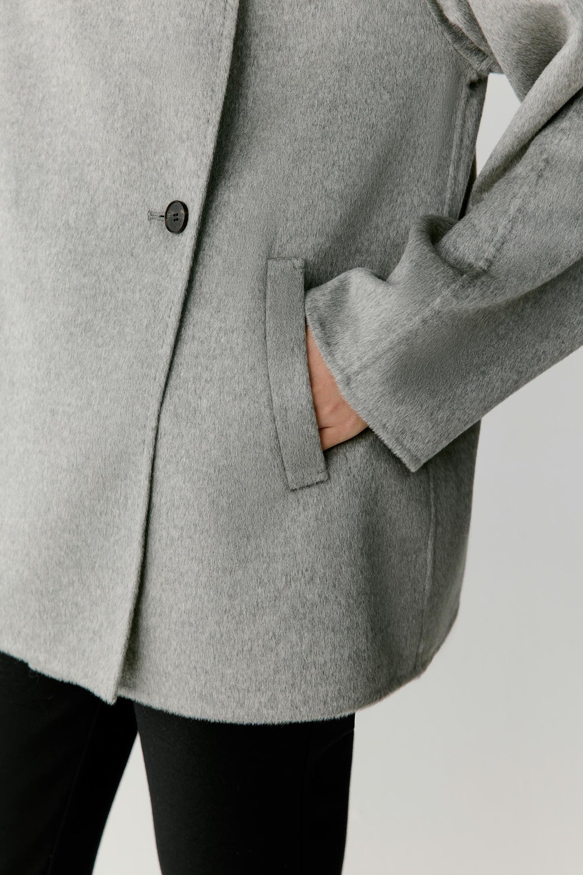 Close-up highlighting the side pocket, sleeve and dense double-face cashmere construction.