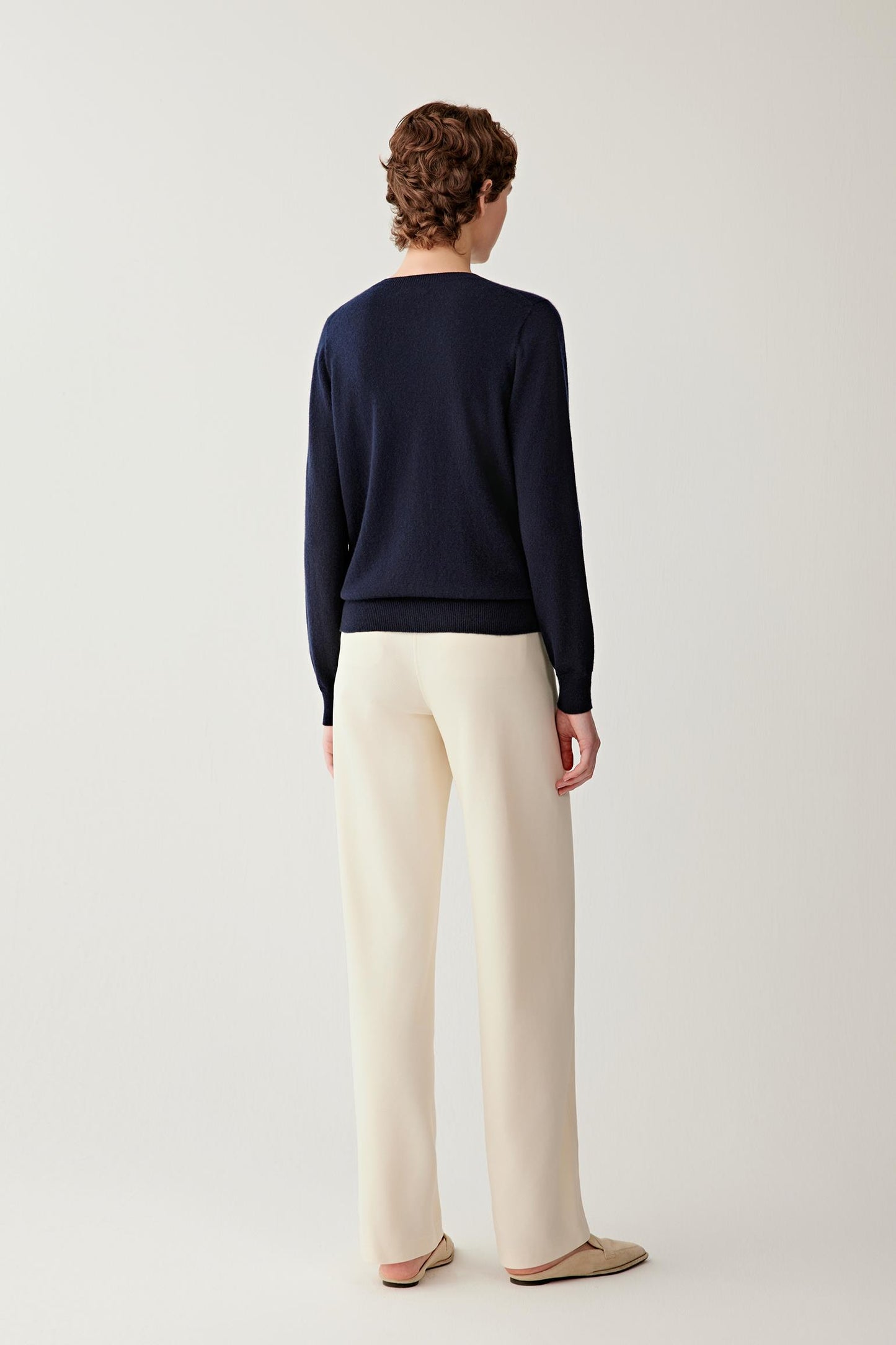 Full-length back view of women’s navy cashmere pullover showing its clean, straight silhouette