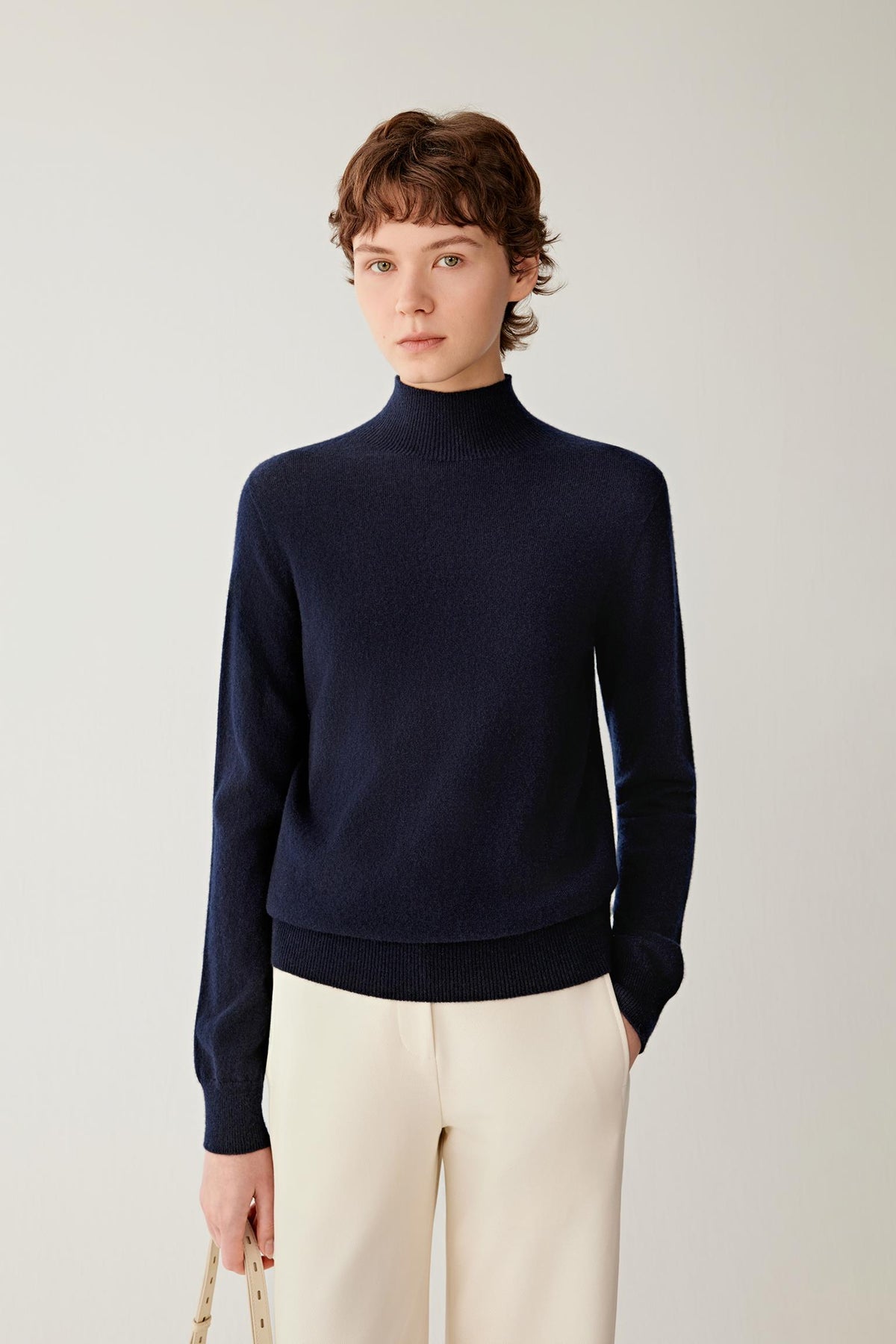 Front view highlighting the mock neck, long sleeves and fine-knit construction of the navy cashmere pullover.