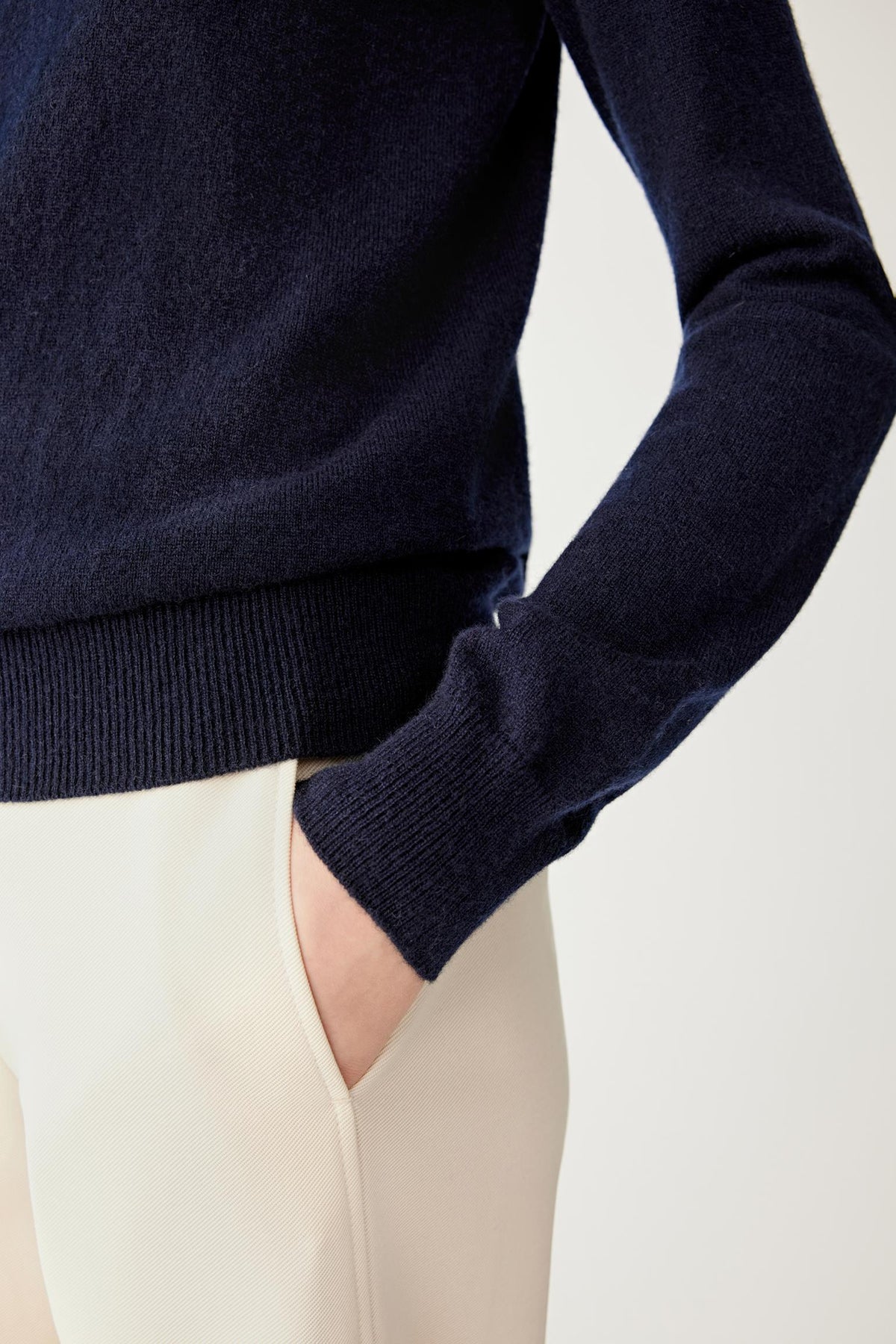 Close-up highlighting the long sleeve and smooth navy cashmere surface.