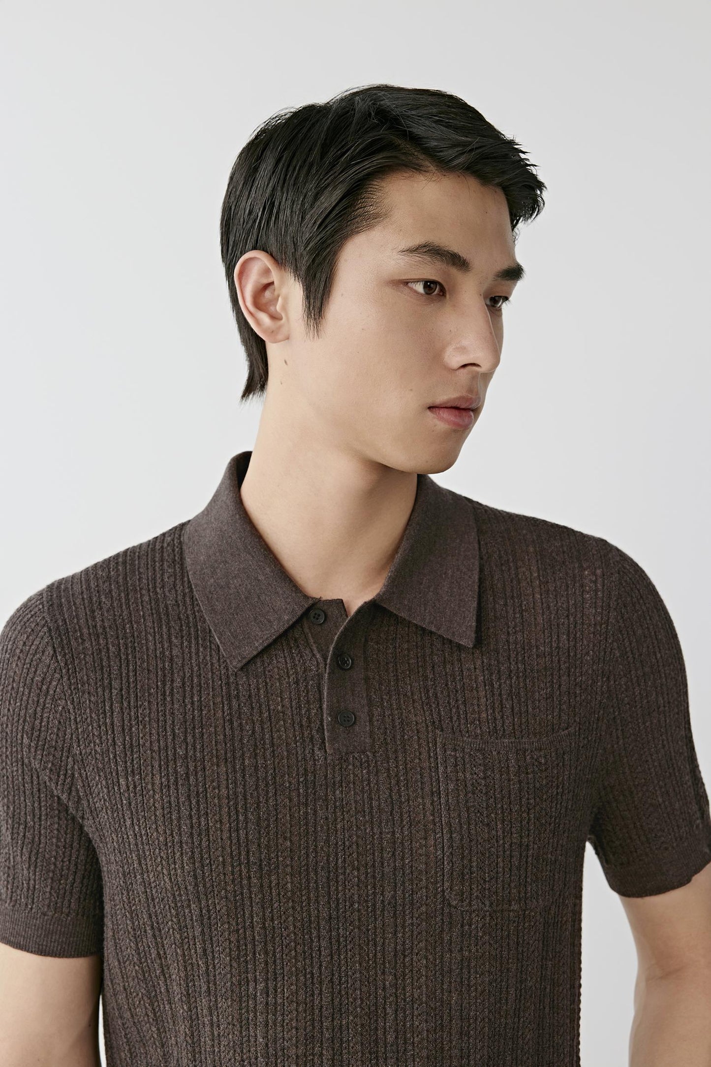 Man wearing a brown knitted polo