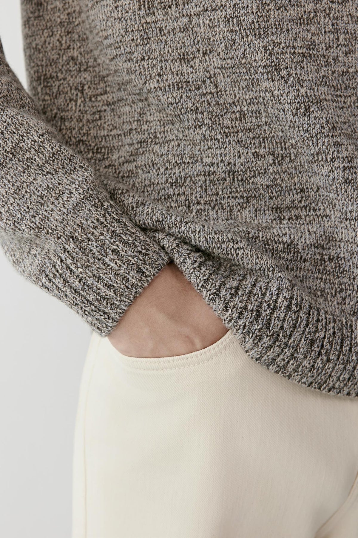 Close-up highlighting the textured grey melange twisted cashmere knit and ribbed hem.