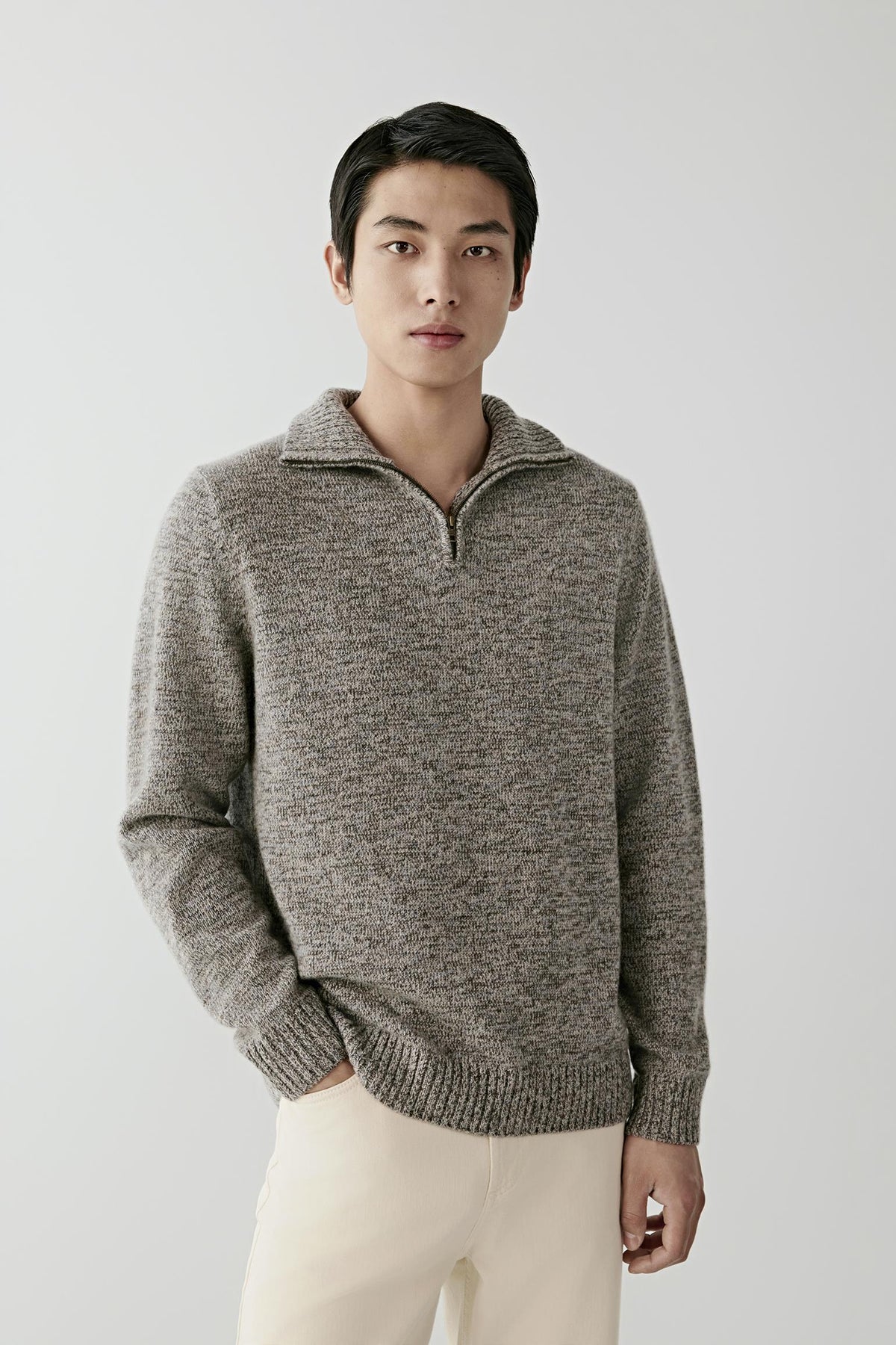 Front view of a man wearing the grey melange twisted cashmere cardigan, highlighting the stand collar, half-zip fastening and ribbed hem.