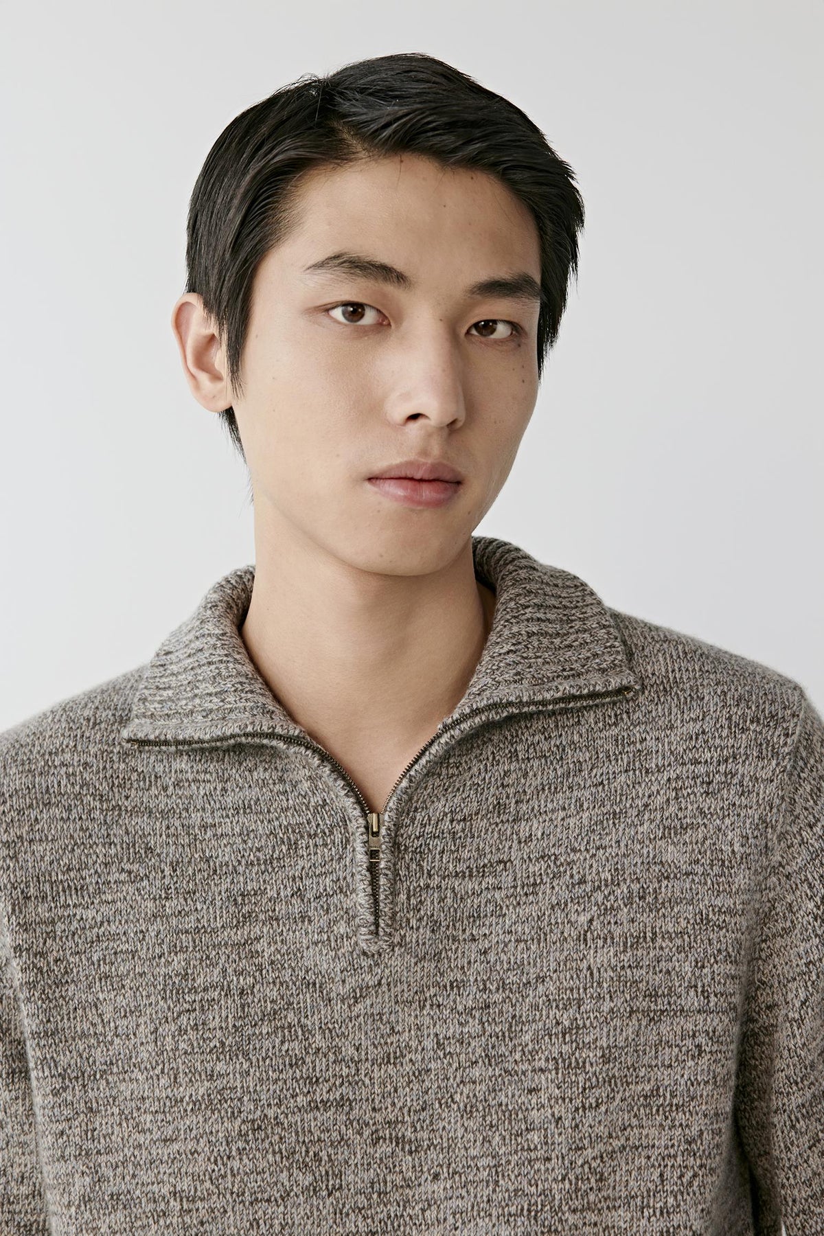 Close-up highlighting the stand collar, half-zip fastening and textured grey melange cashmere knit.