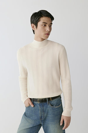 Front view of a man wearing a white cashmere pullover, showing the mock neck, long sleeves and textured cable knit.