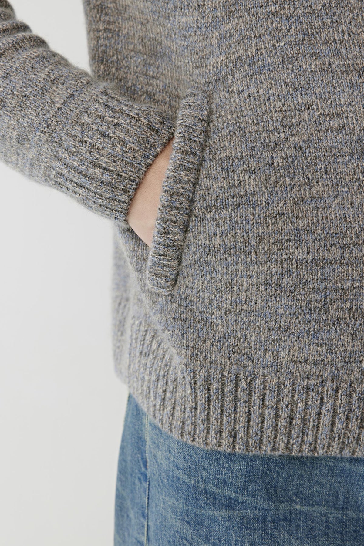 Close-up highlighting the textured grey melange twisted cashmere knit and ribbed hem.