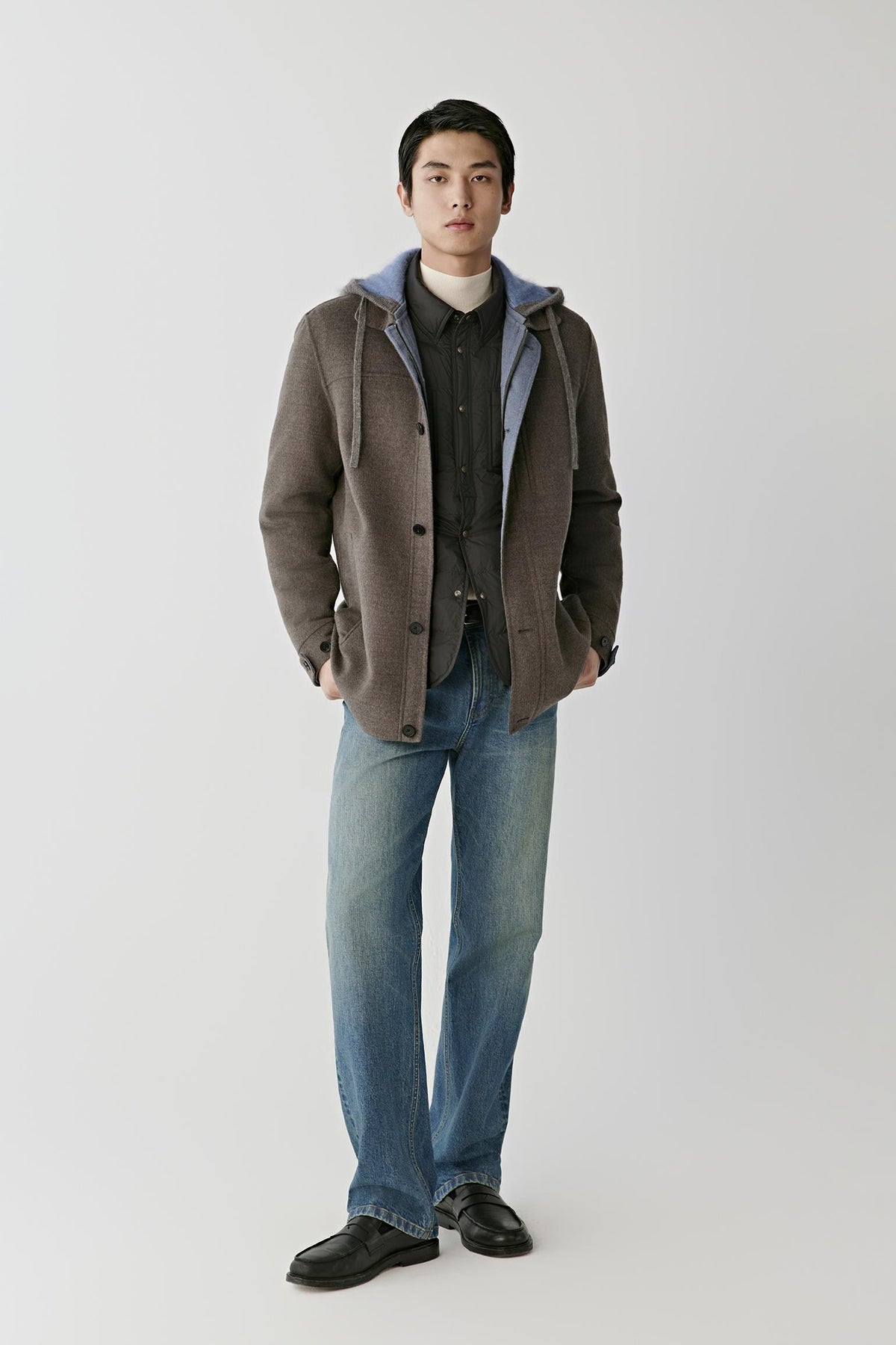Front full-length view of a man wearing the dark brown melange merino wool coat, highlighting the straight silhouette and hooded construction.