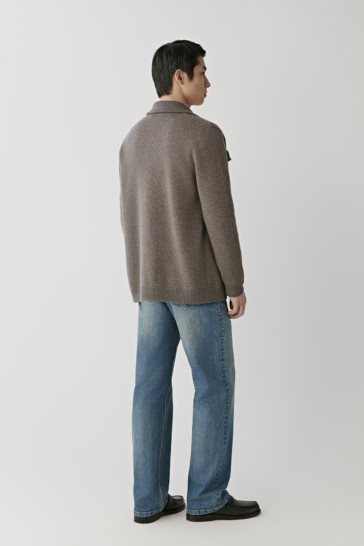 Back view of a man wearing the brown melange cashmere cardigan, showing the straight silhouette and clean knit construction.