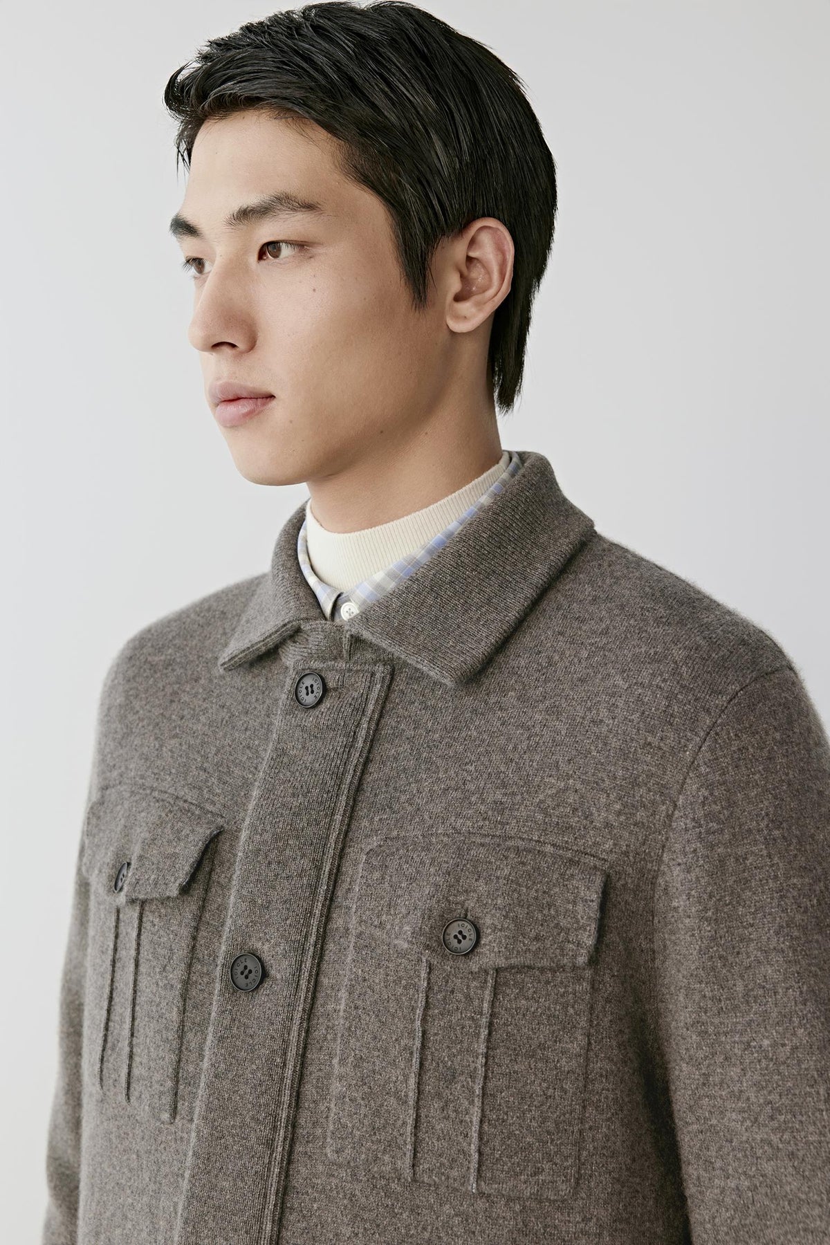 Close-up highlighting the shirt collar, button-front fastening and fine-knit texture of the brown melange cashmere cardigan.