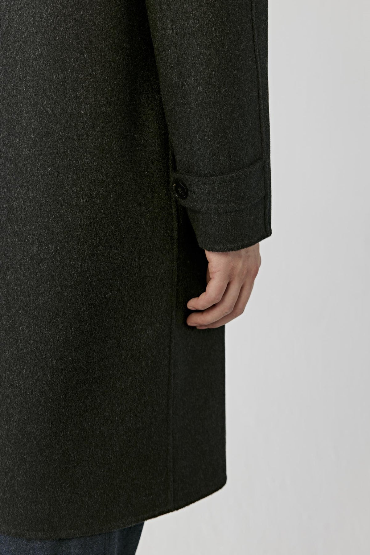 Close-up highlighting the adjustable cuff tab and dark grey double-face cashmere surface.