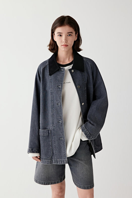 Full-length front view of a female model wearing a smoke grey stretch denim jacket with matching shorts, showing rounded patch pockets and relaxed fit.