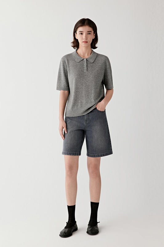Full-length front view of a female model wearing smoke grey stretch denim shorts with a straight cut and relaxed fit.