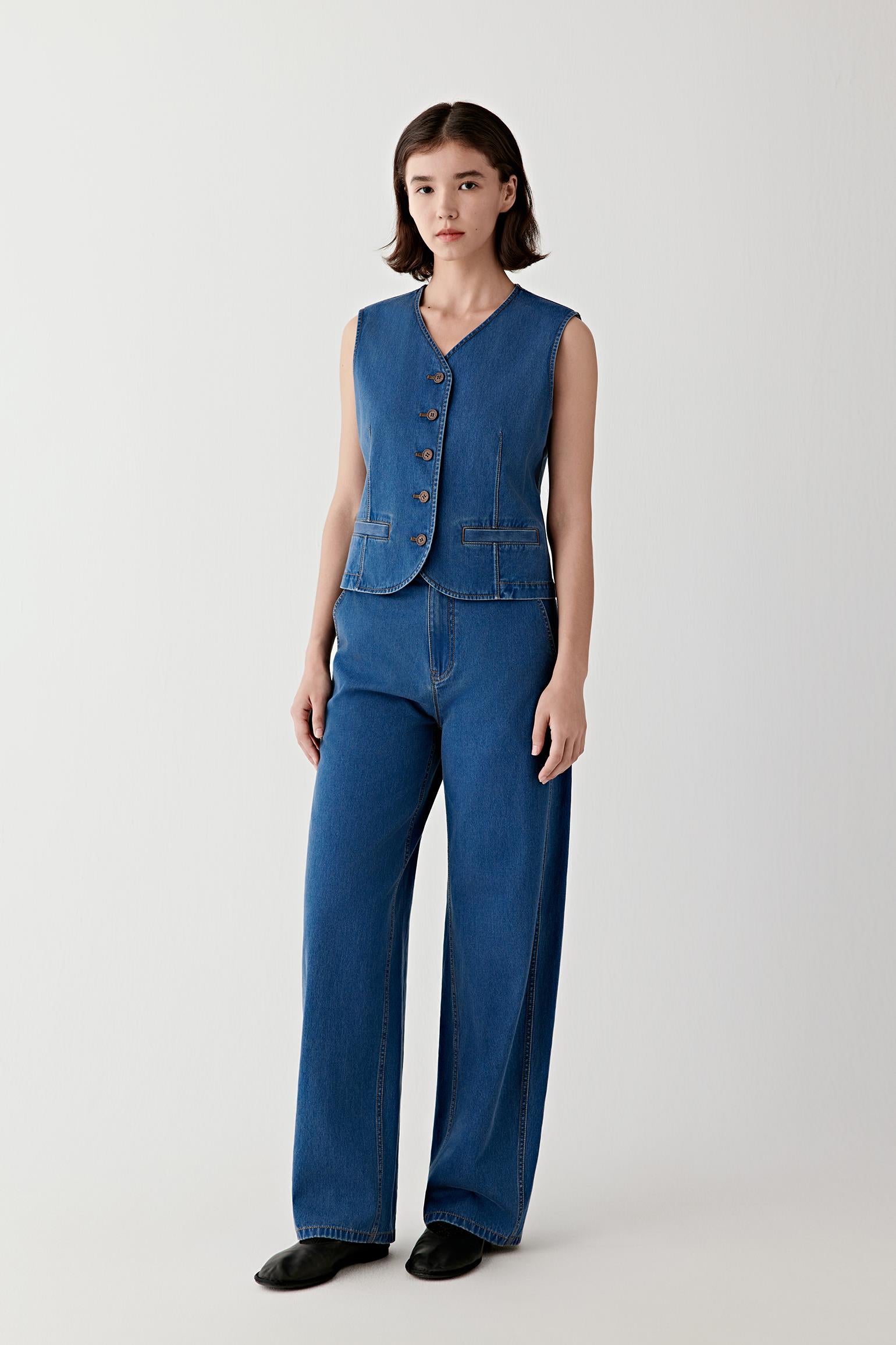 Full-length view of the denim vest styled with matching straight-leg jeans, highlighting the coordinated set, vertical silhouette and clean construction.