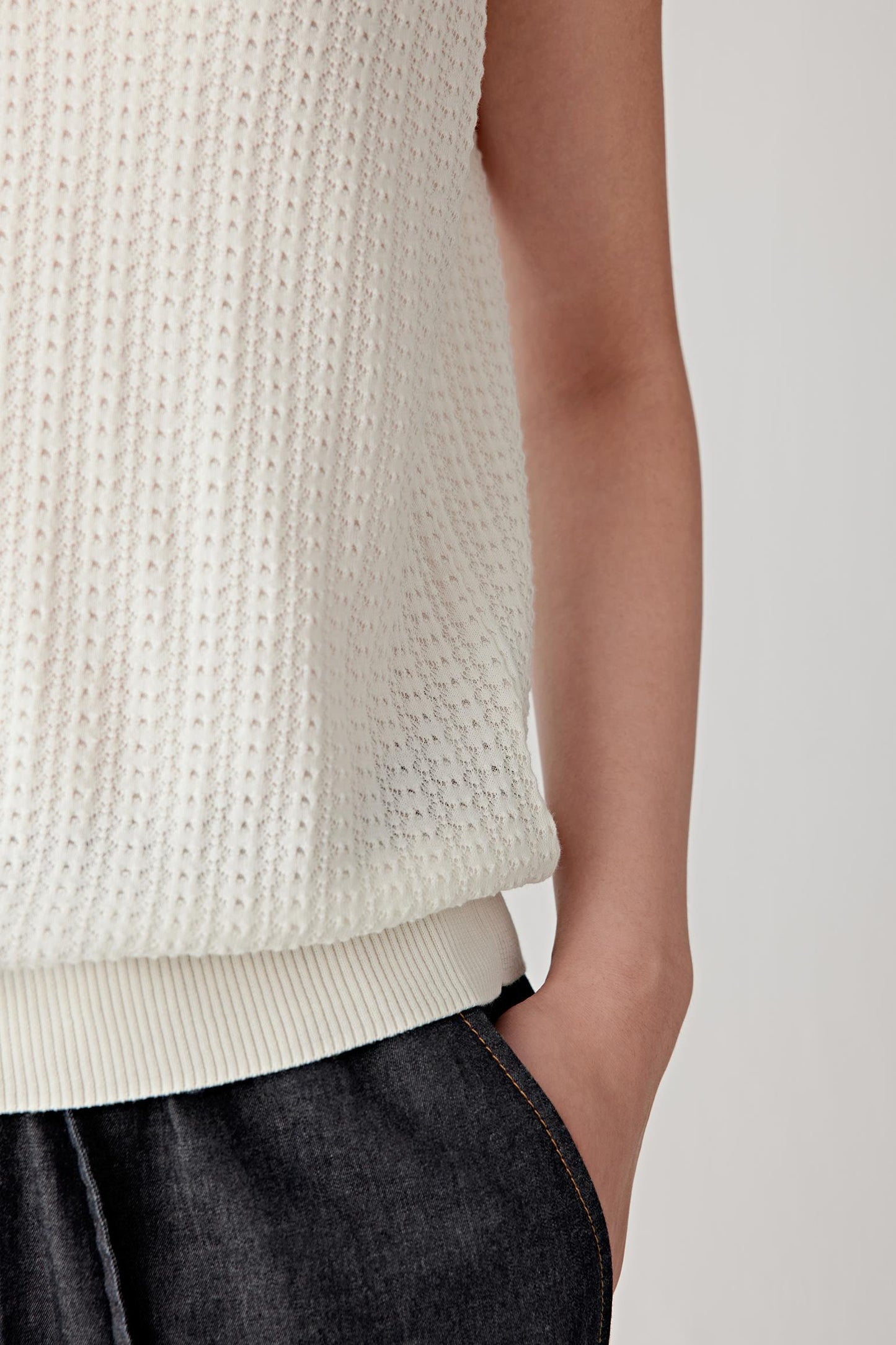 Close-up of the hem and side area, highlighting the ribbed hem finish, clean edges and the vertical continuity of the knit, showing the balance between flexibility and structure