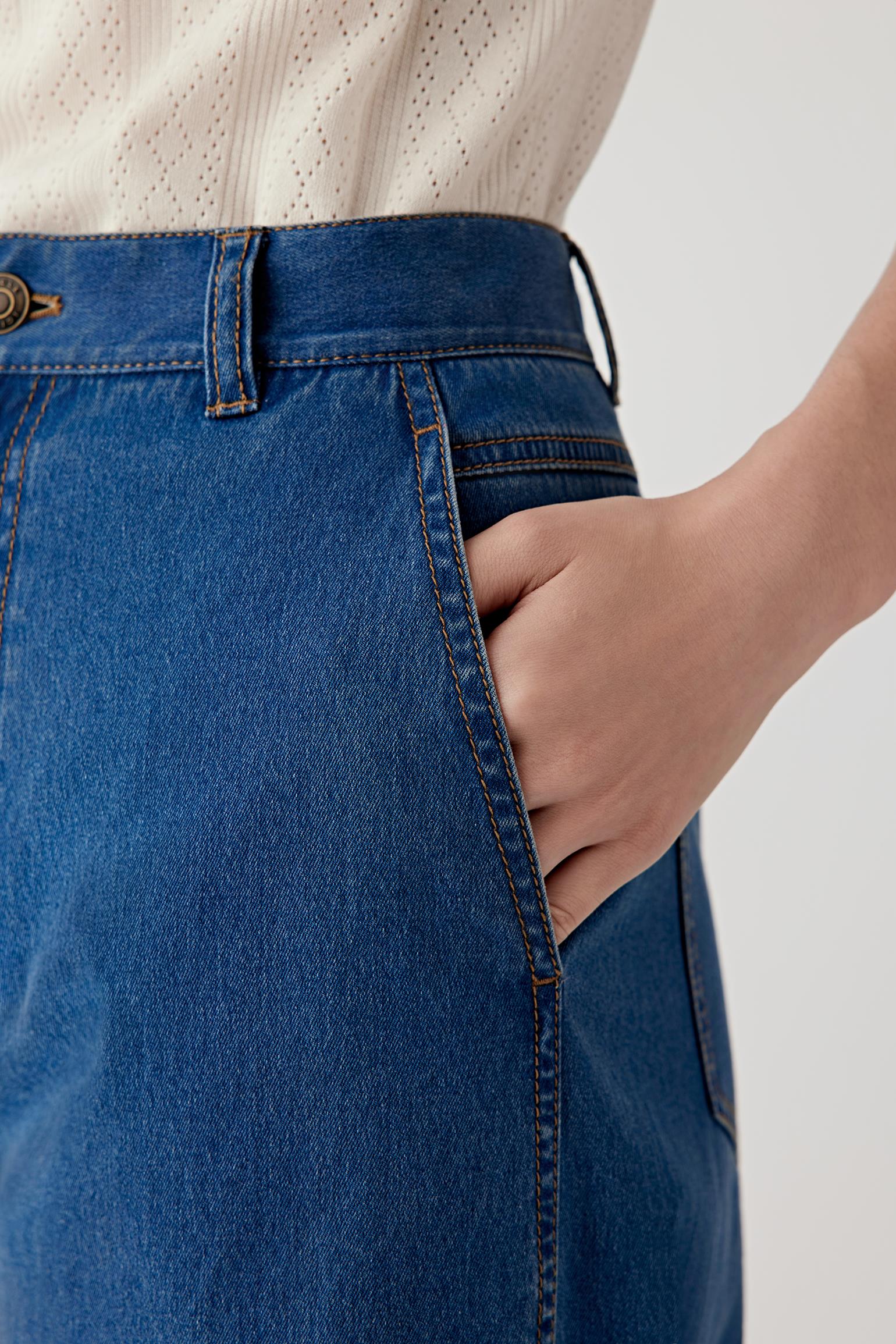 Close-up of the front hip and pocket, revealing the subtle stitching, curved front pocket opening and structured yet soft denim texture.