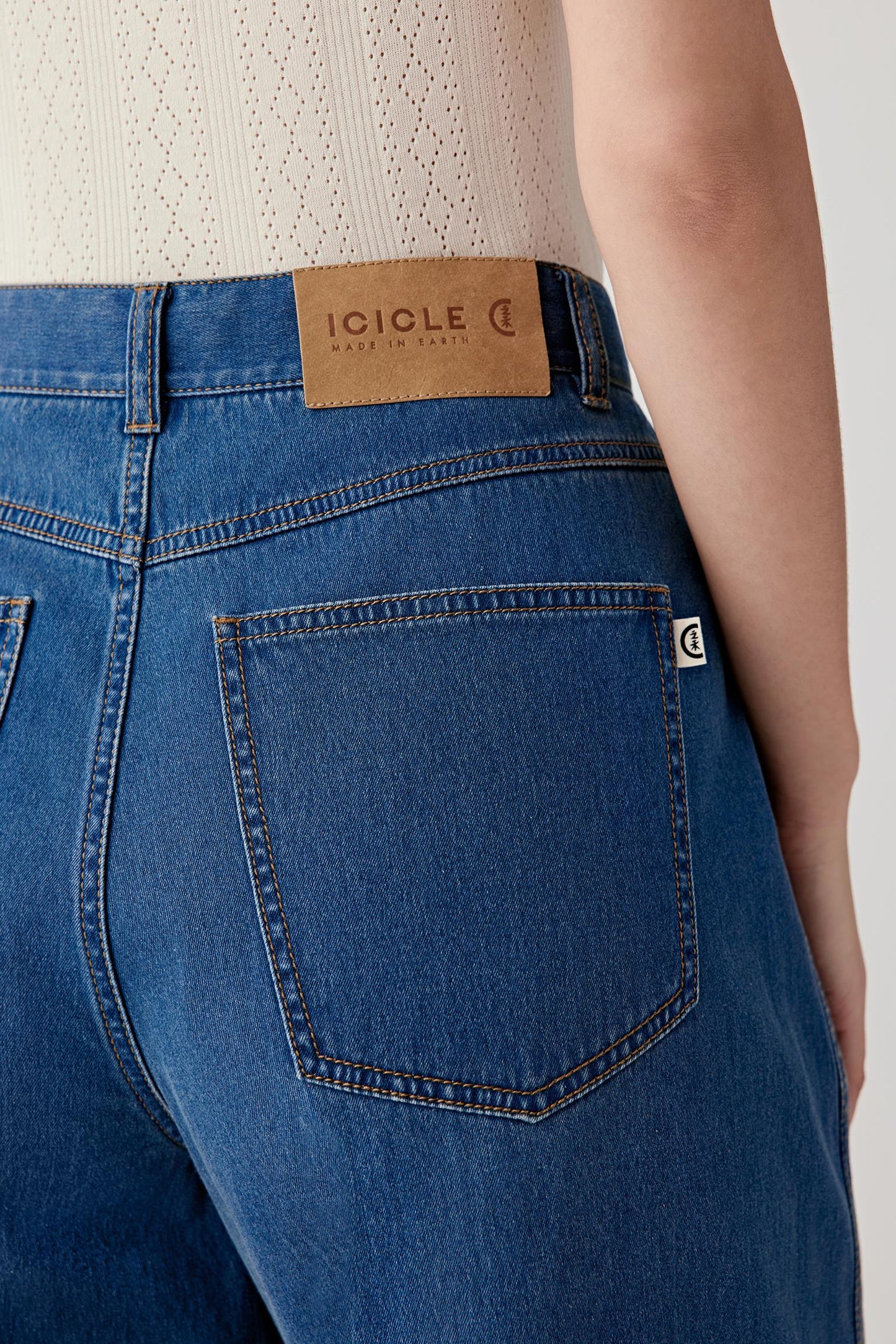 Close-up of the back pocket and waistband, highlighting the contrast stitching, patch pocket construction and leather label detail at the back waist.