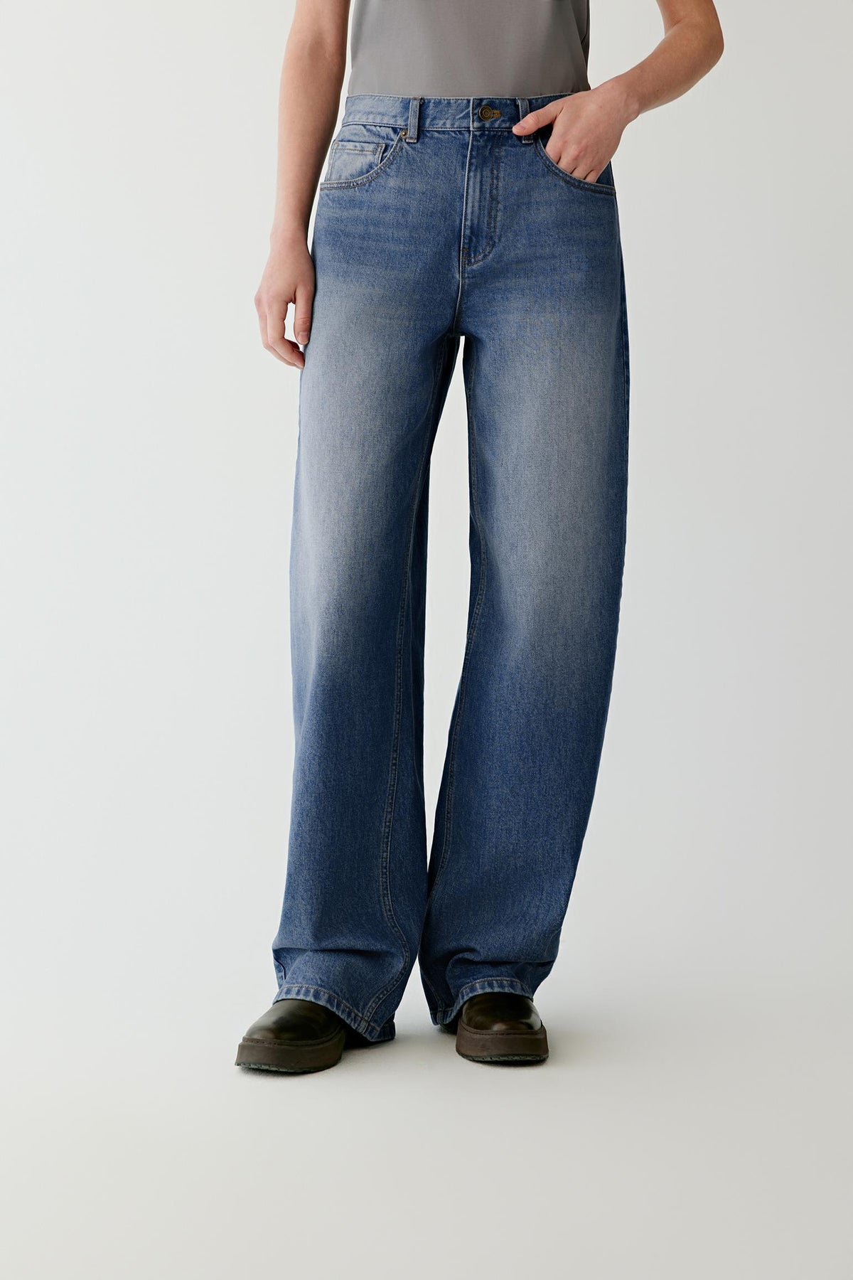 Front view highlighting the wide-leg cut, washed blue denim and subtle fading along the legs.