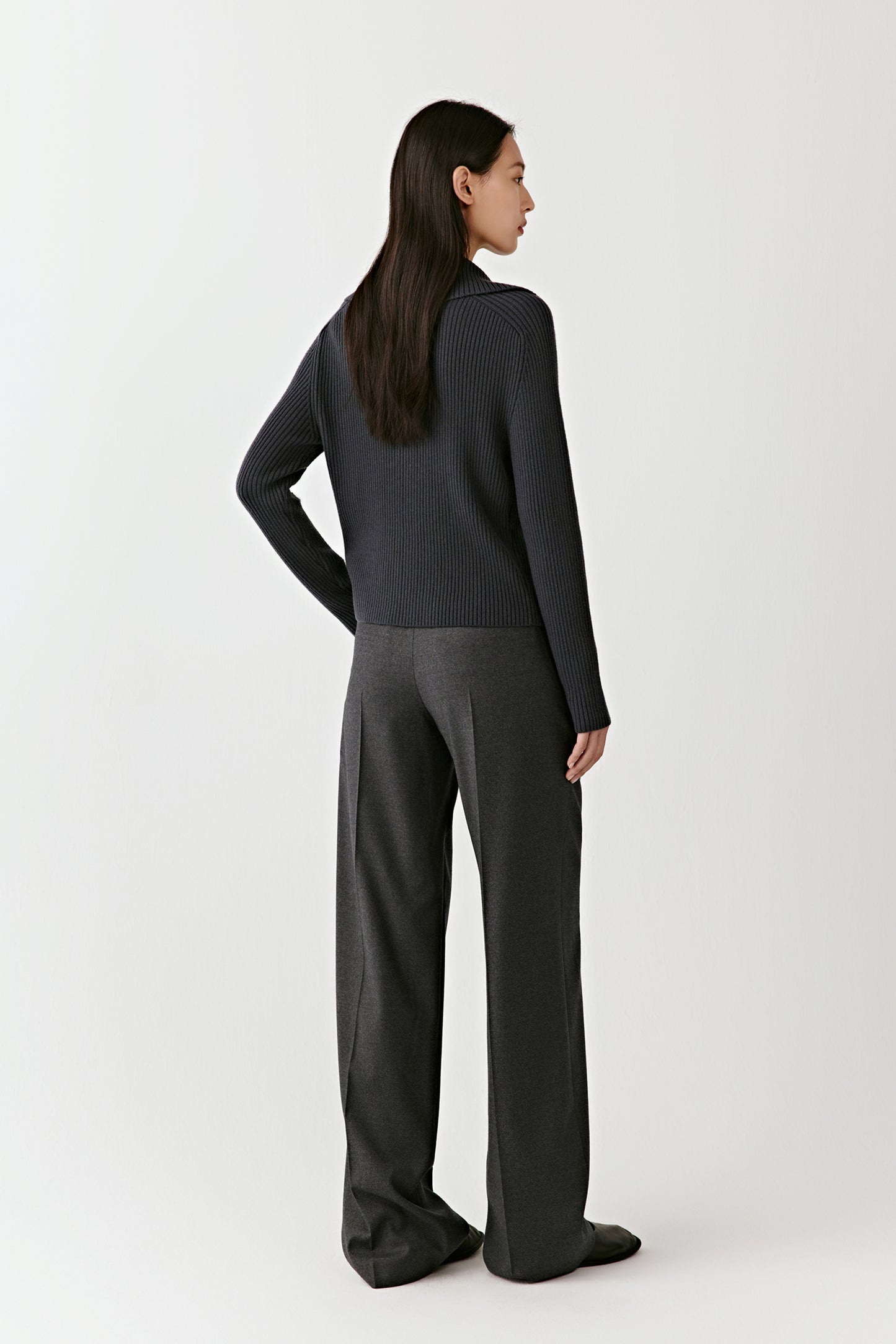 Back view of the blue ribbed wool cardigan, emphasizing the clean lines and tailored structure.