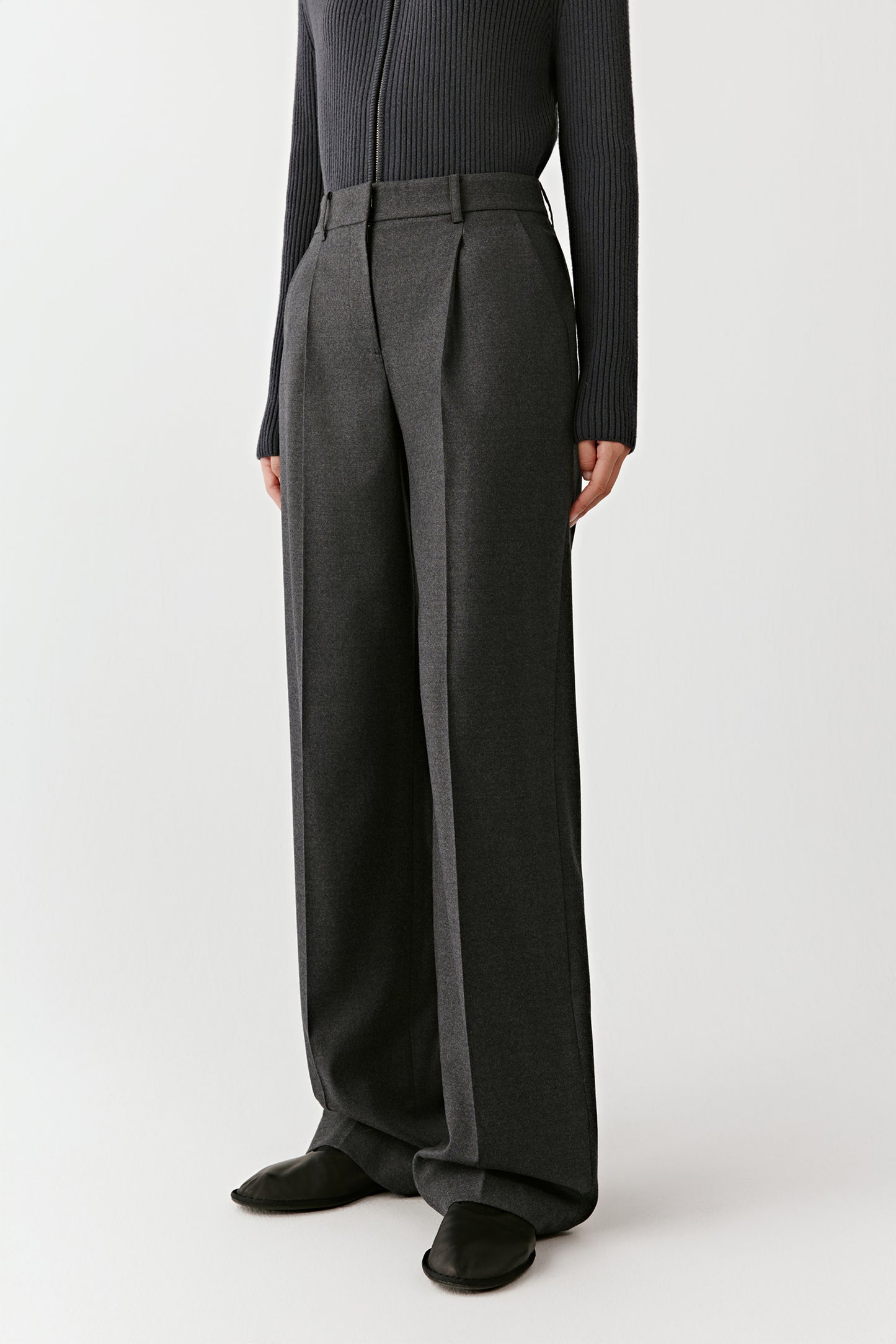 Three-quarter side view of the flannel trousers, showing the tailored cut and soft drape.