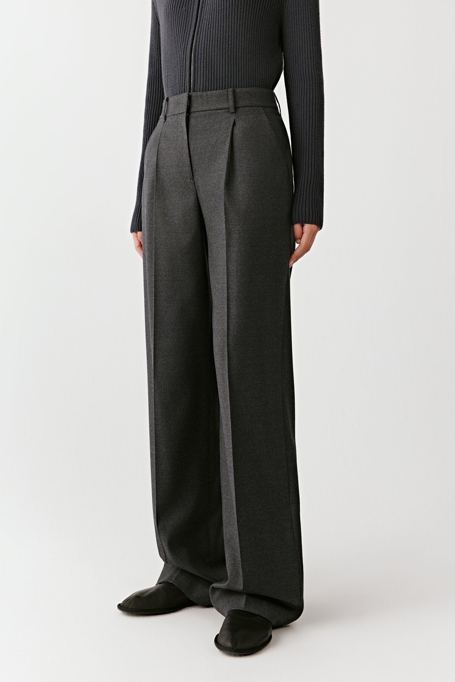 Three-quarter side view of the flannel trousers, showing the tailored cut and soft drape.