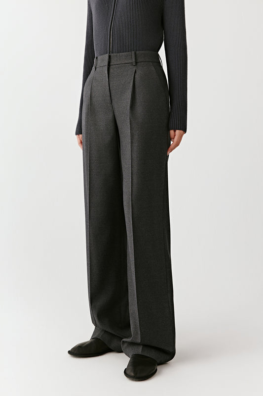 Three-quarter side view of the flannel trousers, showing the tailored cut and soft drape.